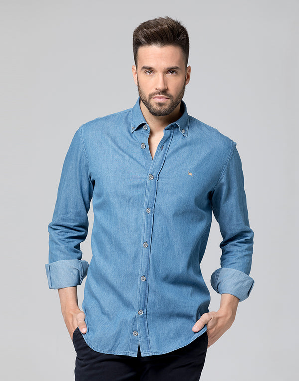 Camisa denim azul confeccionada en algodón 100 % de gran calidad. Patrón regular fit cuello botón y bordado Bowler Hat camel en el pecho.  El modelo mide 1,85 cm. y lleva una talla M